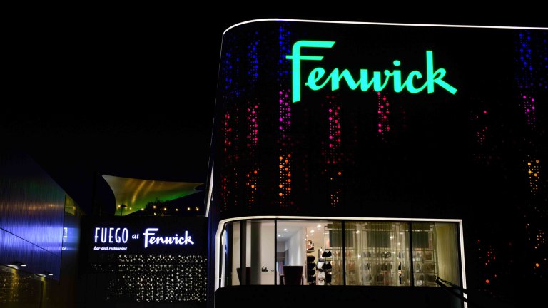 Chris Vaughan Photography - commercial photography | A Fenwick store illuminated at night. The outside of the store is covered in colourful circular lights.