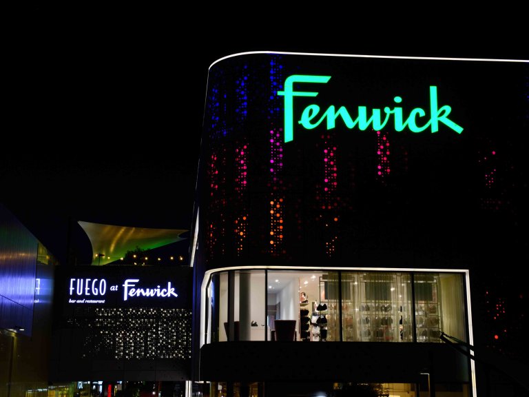 Chris Vaughan Photography - commercial photography | A Fenwick store illuminated at night. The outside of the store is covered in colourful circular lights.