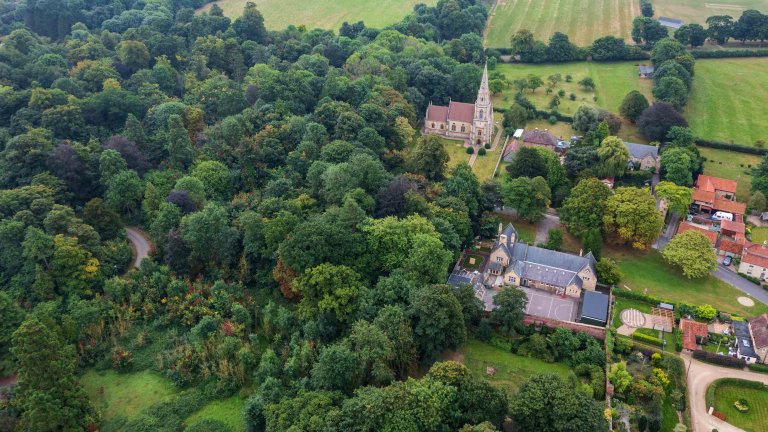 Chris Vaughan Photography - drone images | An aerial image of a village school and church surrounded by trees.