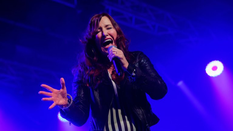 A singer performs on stage during a corporate awards dinner.