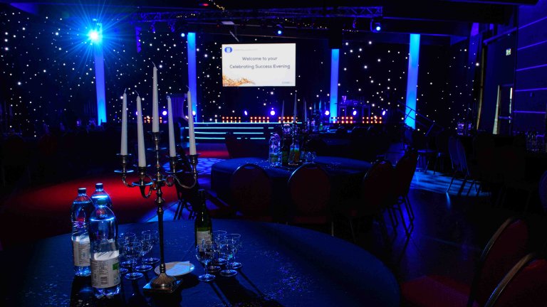 Chris Vaughan Photography - corporate event images | A room set up and lit with blue lighting ahead of an awards ceremony.