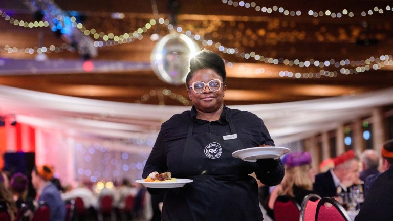 A waitress serves food during a corporate event.