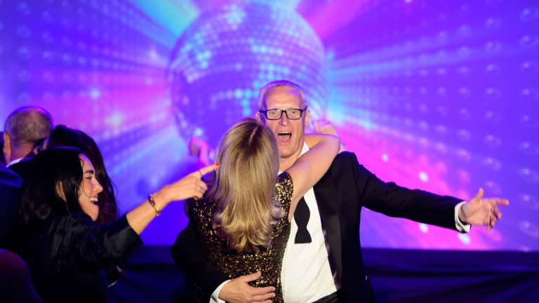 Two guests at a corporate charity fundraising dinner dance.