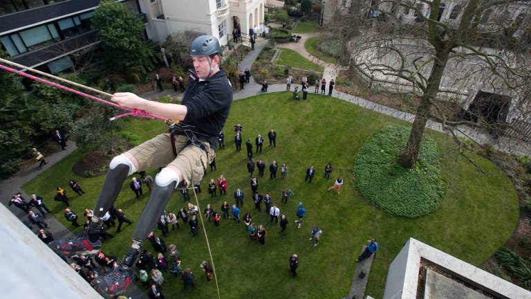 Chris Vaughan Photography - PR and communications images | A double above-knee amputee abseils from a building.