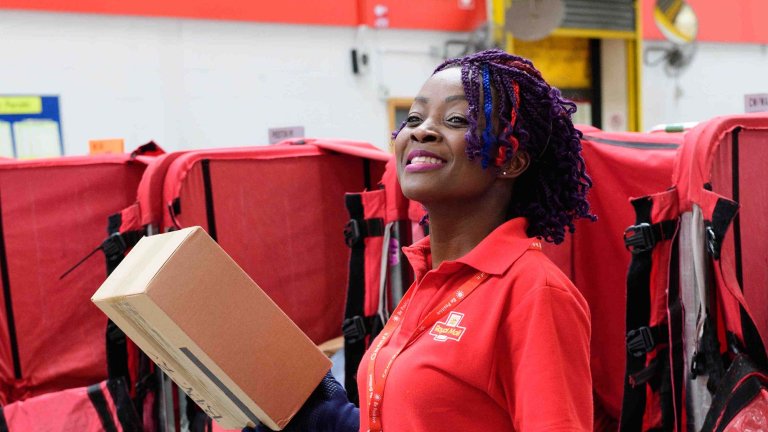 Chris Vaughan Photography - PR and communications images | A postal works sorts post in a mail centre.