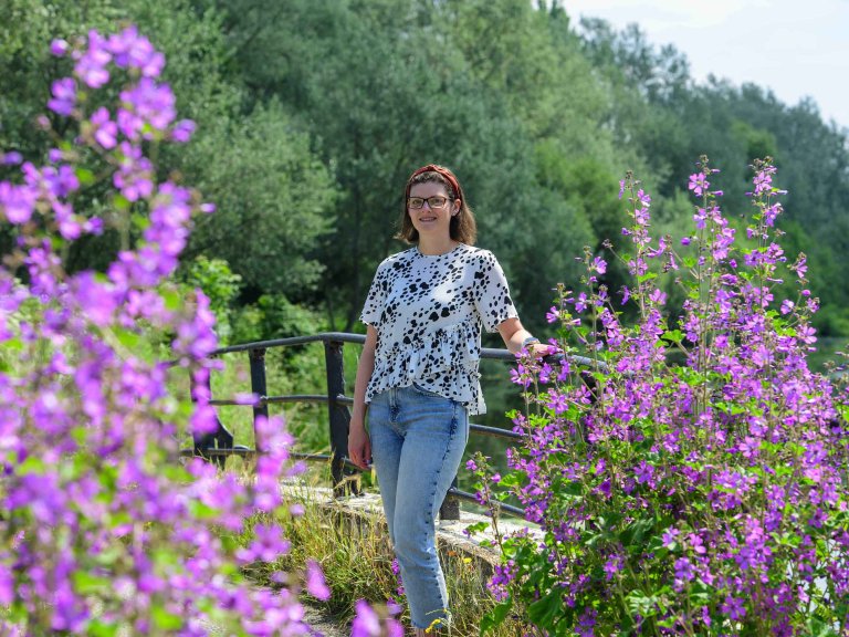 Chris Vaughan Photography - Business profile images | A businesswoman stands surrounded by purple flowers.