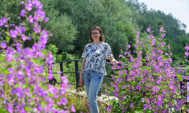 Chris Vaughan Photography - Business profile images | A businesswoman stands surrounded by purple flowers.