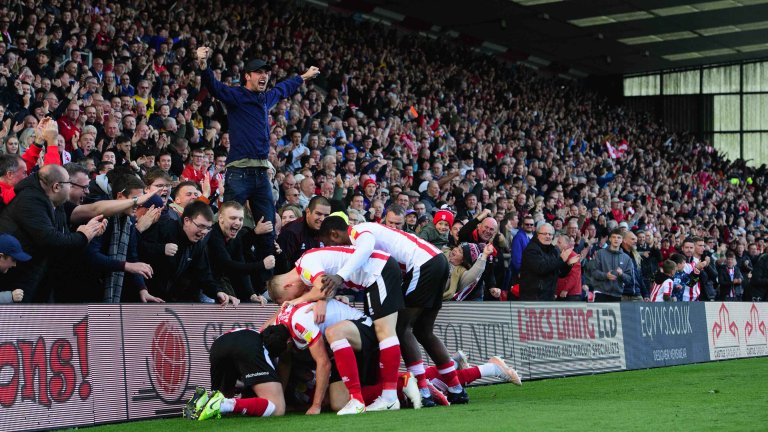 Chris Vaughan Photography - Sports images | Lincoln City players celebrate a late goal in front of a packed stand of fans.