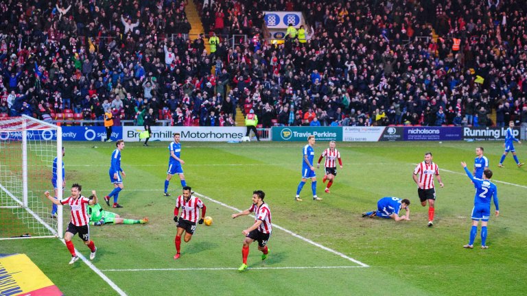 Chris Vaughan Photography - Sports images | Lincoln City's Lee Frecklington celebrates a goal with a stand full of fans in the background.
