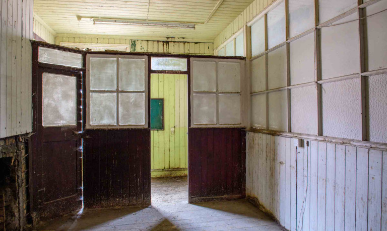 Interior of Building 89 showing glazed timber partitions and connecting rooms.