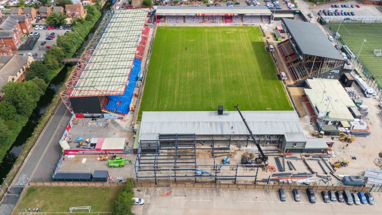 An aerial/drone photograph showing construction progress at the Imps Territory redevelopment.