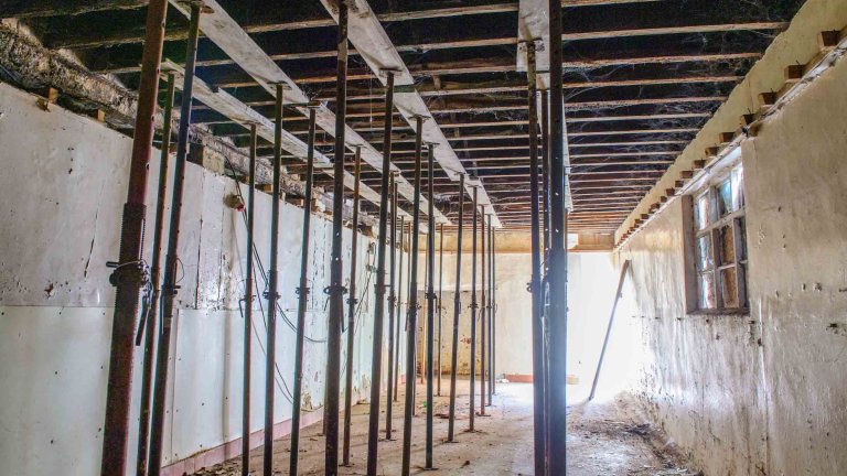 Interior of Peterson&rsquo;s Smokehouse supported by rows of temporary steel props before restoration.