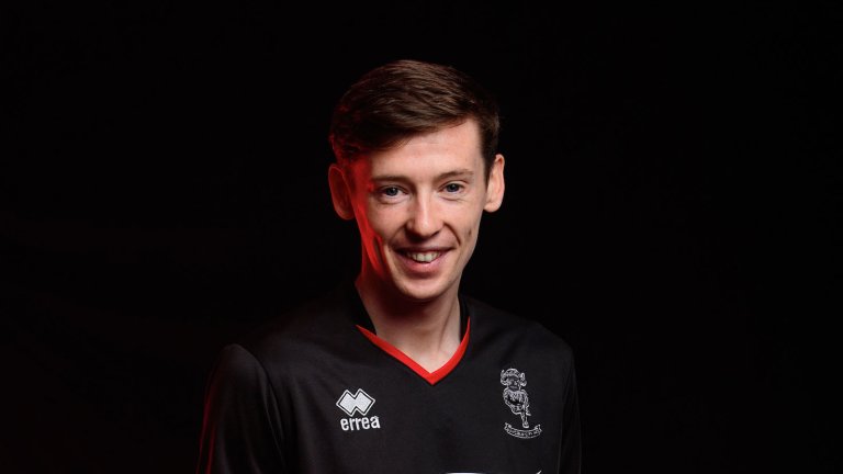 Conor McGrandles wearing the 2020/21 black away kit, photographed against a black background.