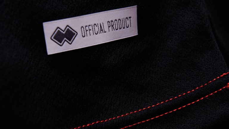 A close up of the red stitching on the black Lincoln City 2020/21 away kit.