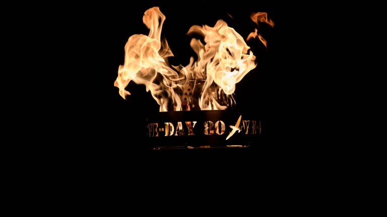 The flame from a beacon lit on the 80th anniversary of VE Day. The beacon has the words VE Day 80 cut out of the sides.