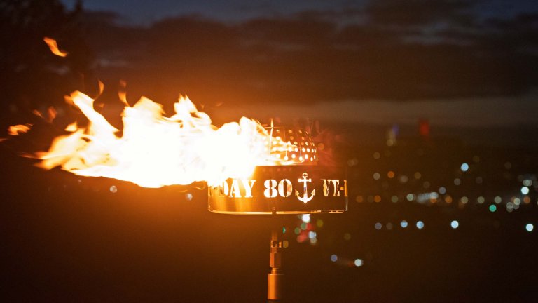 The flame from a beacon lit on the 80th anniversary of VE Day. The beacon has the words VE Day 80 cut out of the sides, with Lincoln Cathedral just visible in the background..