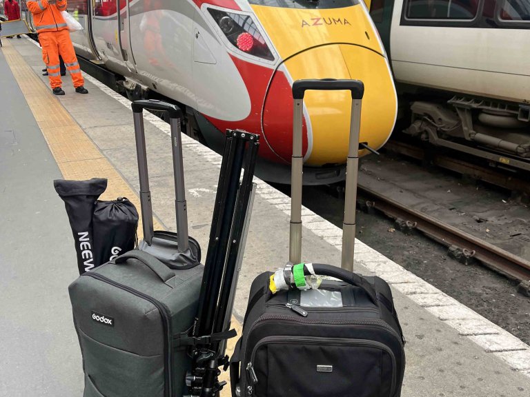 The camera bags belonging to Chris Vaughan Photography on Kings Cross Station with an LNER Azusa train in the background.