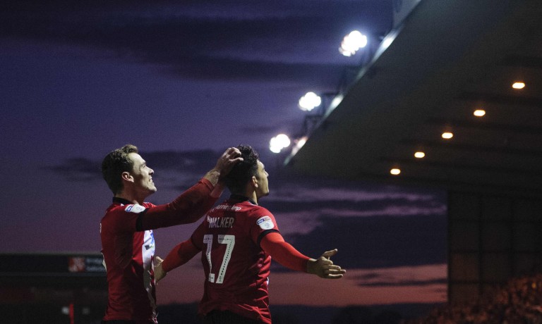 Chris Vaughan Photography - case study: Lincoln City | Lincoln City's Harry Toffolo and Tyler Walker celebrate a goal with a setting sun in the background.