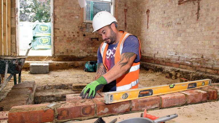 A workman laying bricks inside the Old Kings Head.
