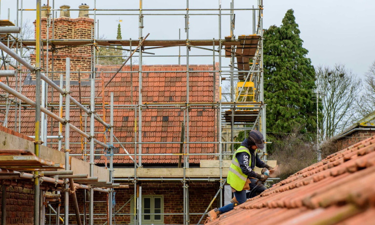 A worker on the roof of the Old Kings Head.
