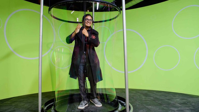 Chris Vaughan - case study images: MathsCity | A young lady surrounds herself with a giant bubble.