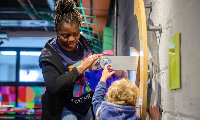 Chris Vaughan - case study images: MathsCity | A colleague helps a young customer with a task.