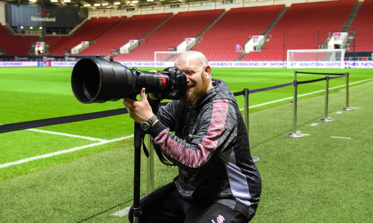 A profile picture of Chris Vaughan, owner of Chris Vaughan Photography at the side of a football pitch.