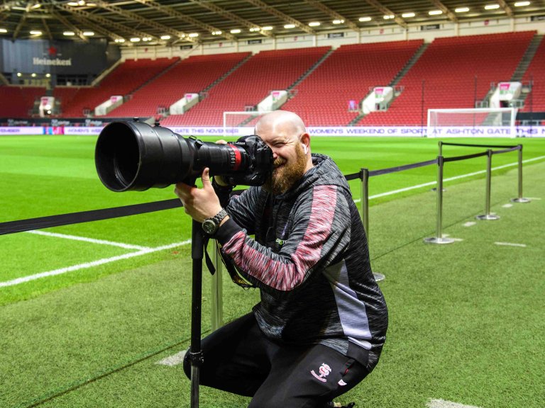 A profile picture of Chris Vaughan, owner of Chris Vaughan Photography at the side of a football pitch.
